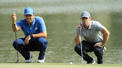 Sergio Garcia and Rory McIlroy line up putts on the ninth