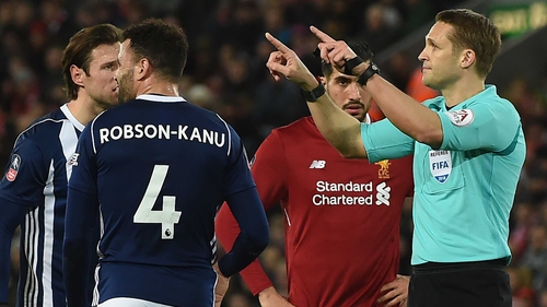 Referee Craig Pawson indicates he's going to the VAR at Anfield