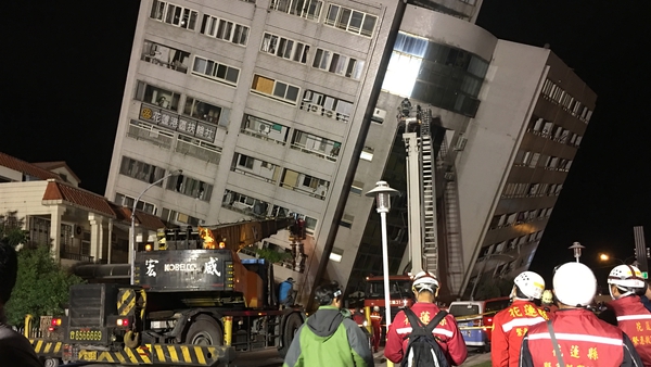 Rescue workers block off the area to search for survivors outside a building after its foundation collapsed in Hualien
