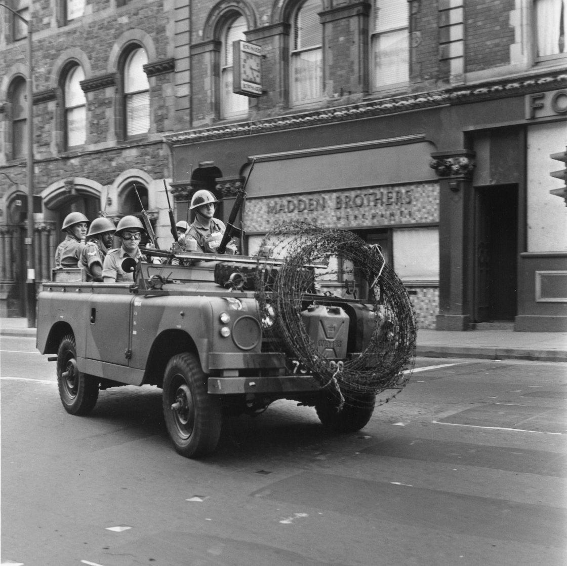 Image - Armed British soldiers driving through Derry City on a mobile patrol, 1969