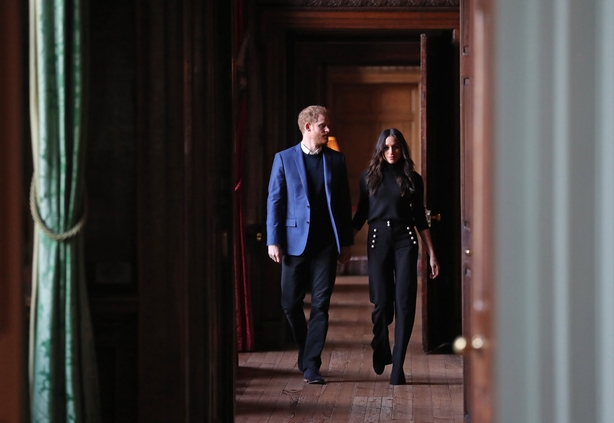 Prince Harry and Meghan Markle walk through the corridors of the Palace of Holyroodhouse