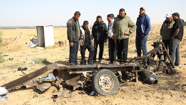 Palestinian men look at the debris of a motorcycle at the site of an explosion in east of Rafah