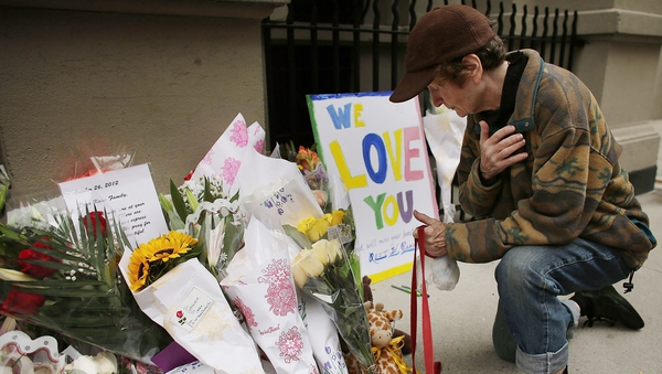 A woman lays flowers outside the Manhattan apartment where Lucia and Leo Krim were stabbed to death in 2012