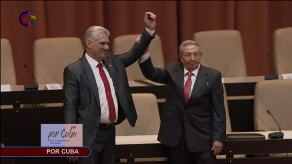 Outgoing Cuban President Raul Castro (right) raises the hand of incoming president Miguel-Diaz Canel