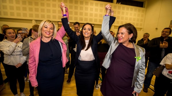 Michelle O'Neill (left) and Mary Lou McDonald raise the arms of Órfhlaith Begley as the newly-elected Sinn Féin MP for West Tyrone