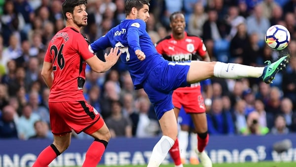 Christopher Schindler of Huddersfield Town looks on as Alvaro Morata of Chelsea shoots