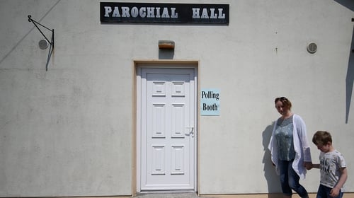 A woman arrives at a polling station with her son in Roscommon today
