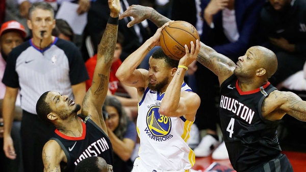Stephen Curry of the Golden State Warriors goes up against Trevor Ariza and PJ Tucker of the Houston Rockets