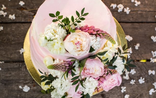 Big pink wedding cake decorated by flowers