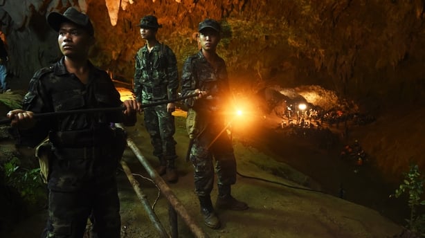 Thai soldiers relay electric cable deep into the Tham Luang cave