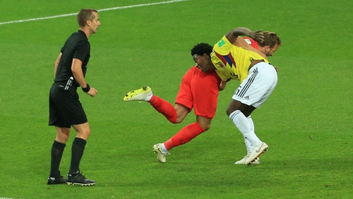 Carlos Sanchez of Colombia fouling Harry Kane of England in front of referee Mark Geiger