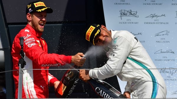 Ferrari's Sebastian Vettel (L) celebrates winning the British Grand Prix with second-placed Mercedes driver Lewis Hamilton