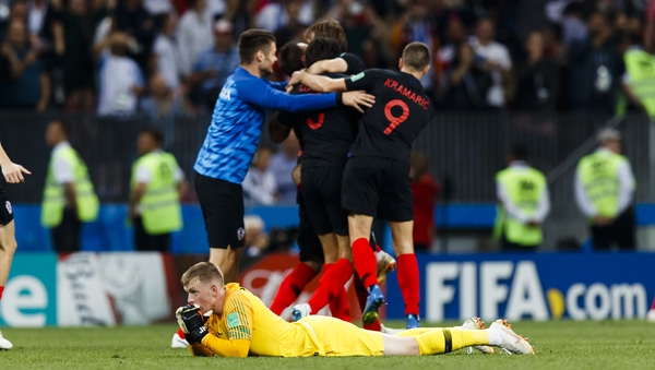 England goalkeeper Jordan Pickford looks dejected while Croatian players celebrate their win