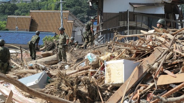 Rescue teams search for missing people at a flood damage site in Kure, Hiroshima