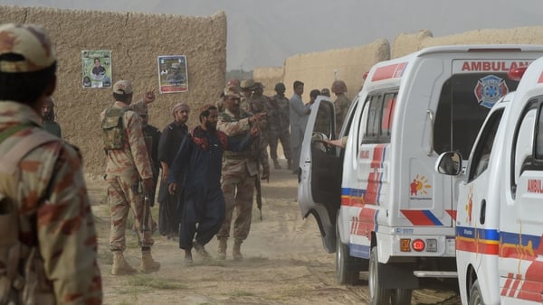 People move injured victims of the bomb attack from the scene in Mastung