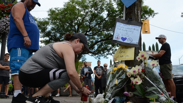 People in Toronto add flowers and messages to a memorial remembering the victims of the shooting