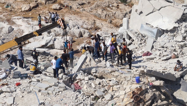Syrian civil defence members conduct search and rescue operations at the wreckage in Idlib, Syria