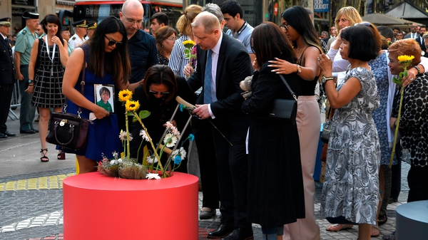 The family of one of the young victims of the attack - Julian Alessandro Cadman - plant flowers ahead of the ceremony
