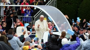 Pope Francis waves to wellwishers as the popemobile travels to the Marian Shrine