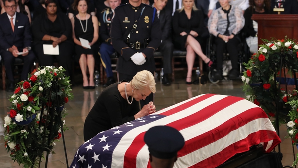 Cindy McCain, wife of John McCain, touches the casket during the ceremony