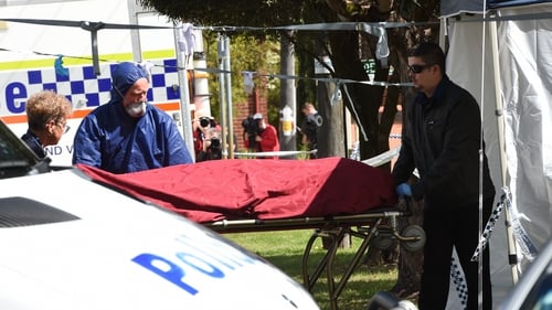 Officials remove a body from the crime site in the suburb of Australia's western city of Perth