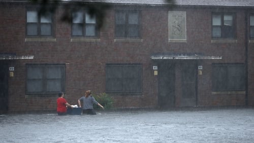 Residents wade through floodwater to retrieve belongings after the Neuse River went over its banks in New Bern