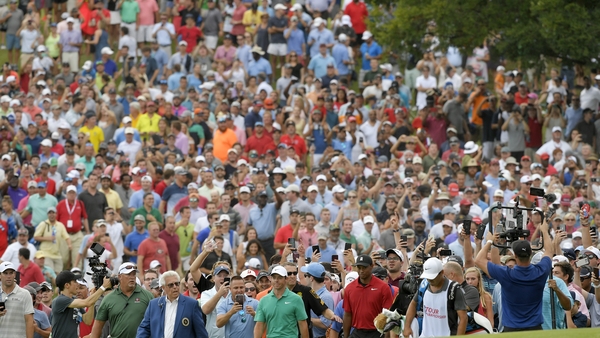 Spectators flock behind Tiger Woods and Rory McIlroy as they make their way to the 18th green in the final round of the Tour Championship