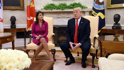 Donald Trump speaks as Nikki Haley, the US Ambassador to the UN, looks on in the Oval office of the White House today