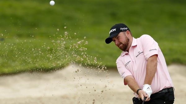 Shane Lowry plays a bunker on the 16th hole