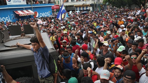 Members of the migrant caravan push forward at a gate separating Guatemala from Mexico in Ciudad Tecun Uman, Guatemala