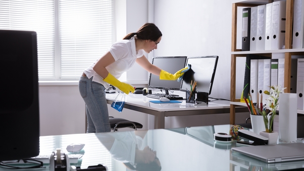 Woman Cleaning Computer In Office