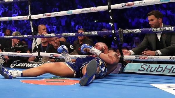 Eddie Hearn checks on Tony Bellew of England after he is knocked out by Oleksandr Usyk