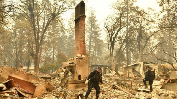 Emergency service personnel search for human remains at a burned residence in Paradise, California