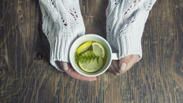 Cup of tea with thyme herb and lemon slices