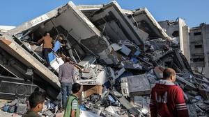 Palestinians inspect the rubble of a building hit during an Israeli airstrike
