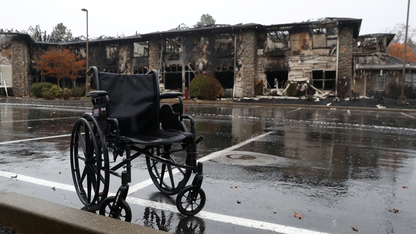 A wheelchair sits in front of a senior living facility that was destroyed by fire in Paradise, California