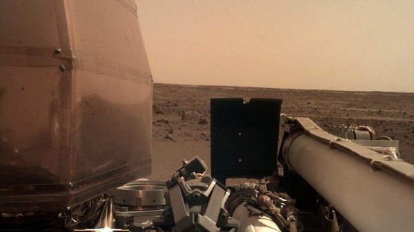 The image shows part of the spacecraft and the Martian surface in the distance