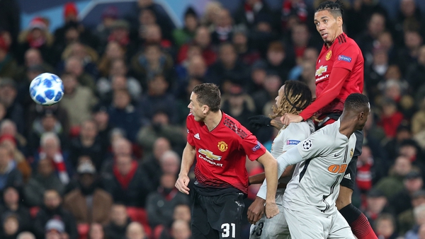 Manchester United defender Chris Smalling leaps above Kevin Mbabu of Young Boys at Old Trafford