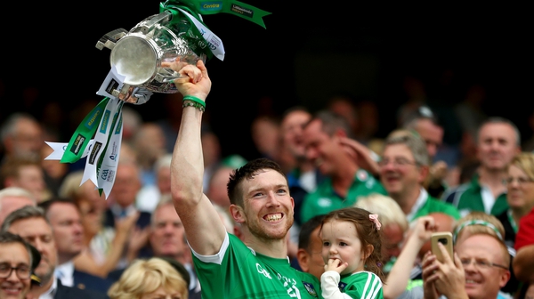 Seamus Hickey holds aloft the Liam MacCarthy trophy with his daughter Anna