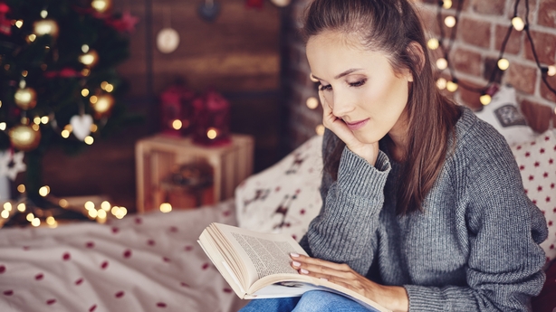 Woman reading a book in bedroom at christmas