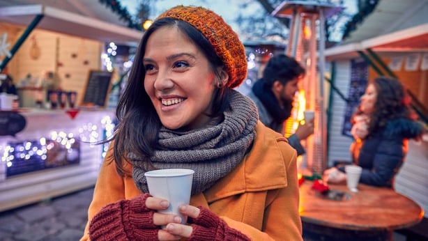 Woman Having Hot Drink Outdoors On Winter Market