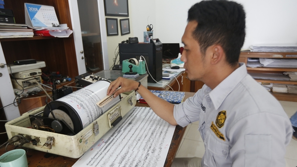 An officer examines a seismograph at the Anak Krakatau volcano monitoring station in Indonesia