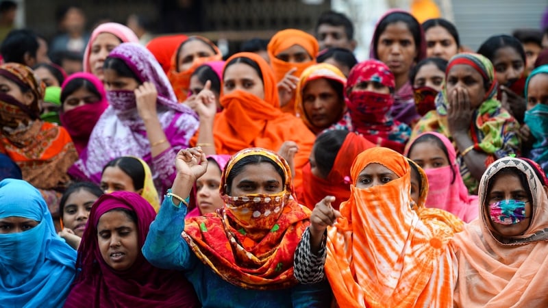 Bangladeshi garment workers block a road during a demonstration to demand higher wages in Dhaka
