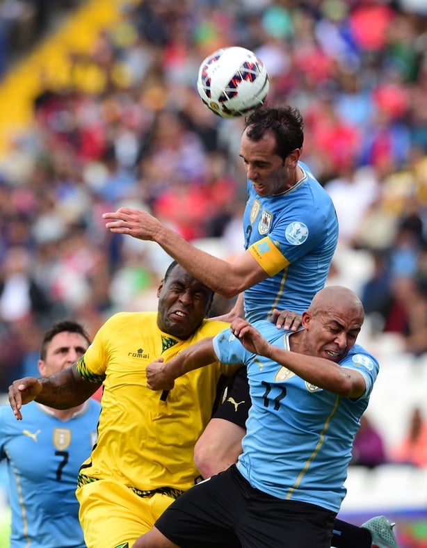 Romeo Parkes battling for possession with Uruguay's Diego Godin