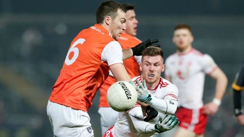 Tyrone's Declan McClure gets off a handpass under pressure form Brendan Donaghy of Armagh