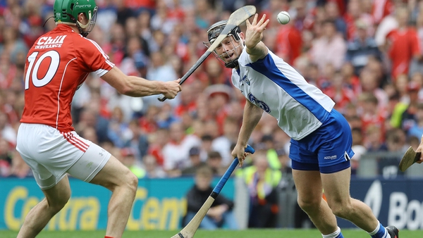 Philip Mahony of Waterford hand passes the ball away from Cork's Seamus Harnedy