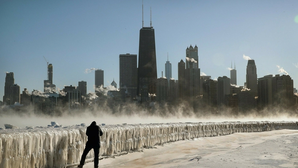 A man takes a picture along the frozen lakefront in Chicago