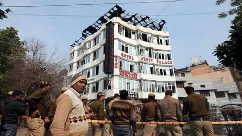 Locals and police on the scene at the hotel where a fire broke out in New Delhi
