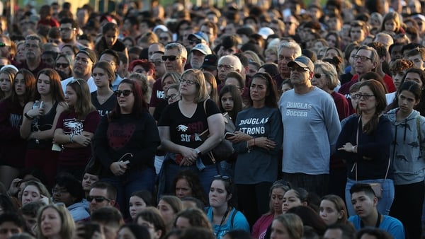 People attend a memorial service at Pine Trails Park for the victims of the mass shooting
