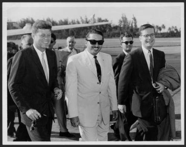 "The then Senator John F. Kennedy walking from the plane to the site where he spoke to reporters at the Isla Verde airport on his first visit to San Juan on Dec 15, 1958. At the center Mr. José A. Benítez and on the right a companion of Mr. Kennedy. " Information: El Mundo, Dec. 15, 1961